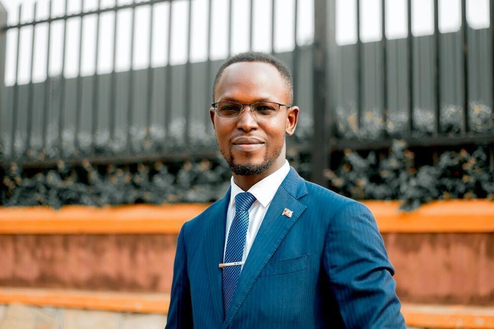 A young professional LeadMinds Africa graduate smiling in a sharp suit.